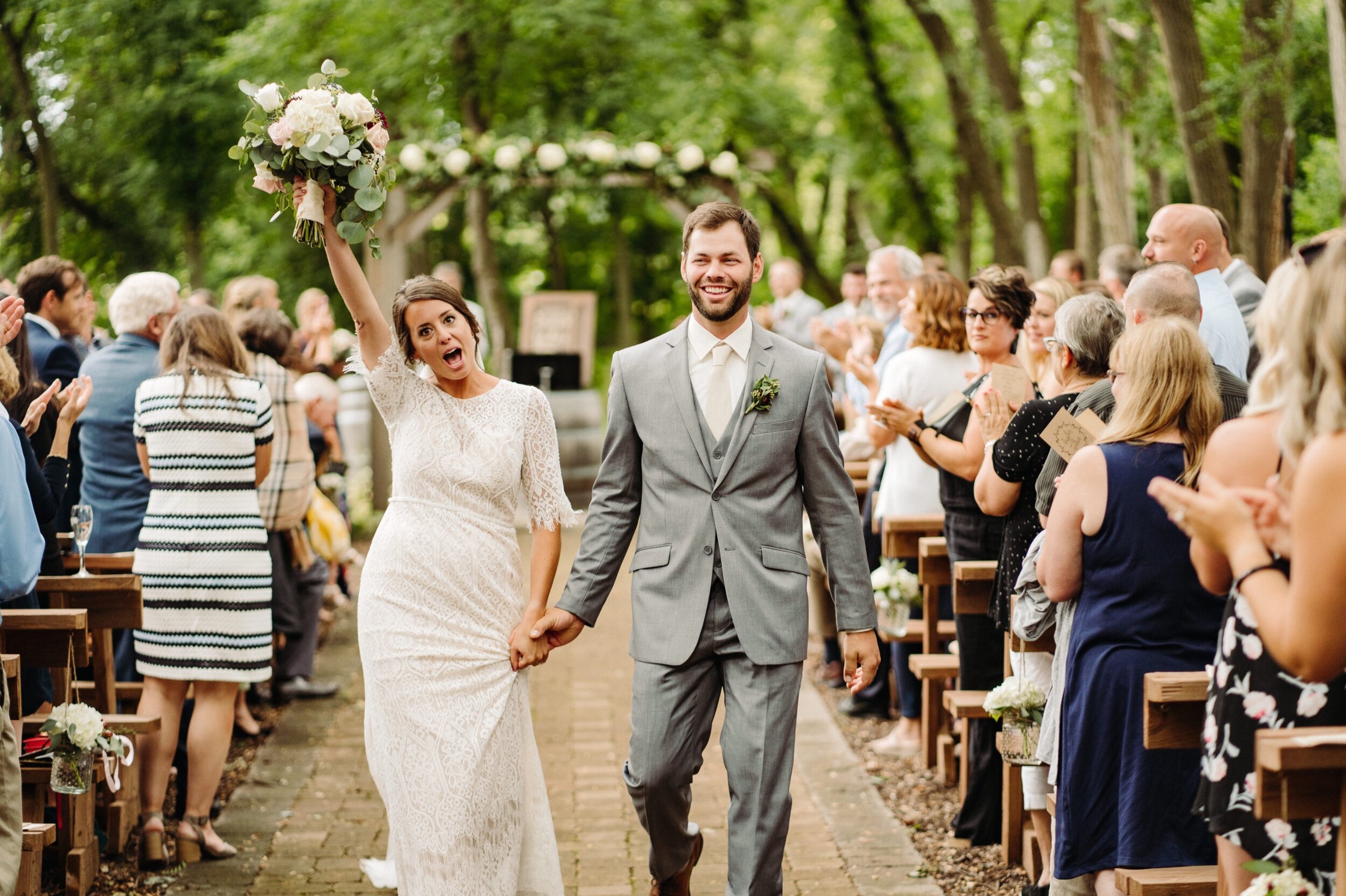 Minneapolis Bride and Groom exiting their ceremony with guests cheering.
