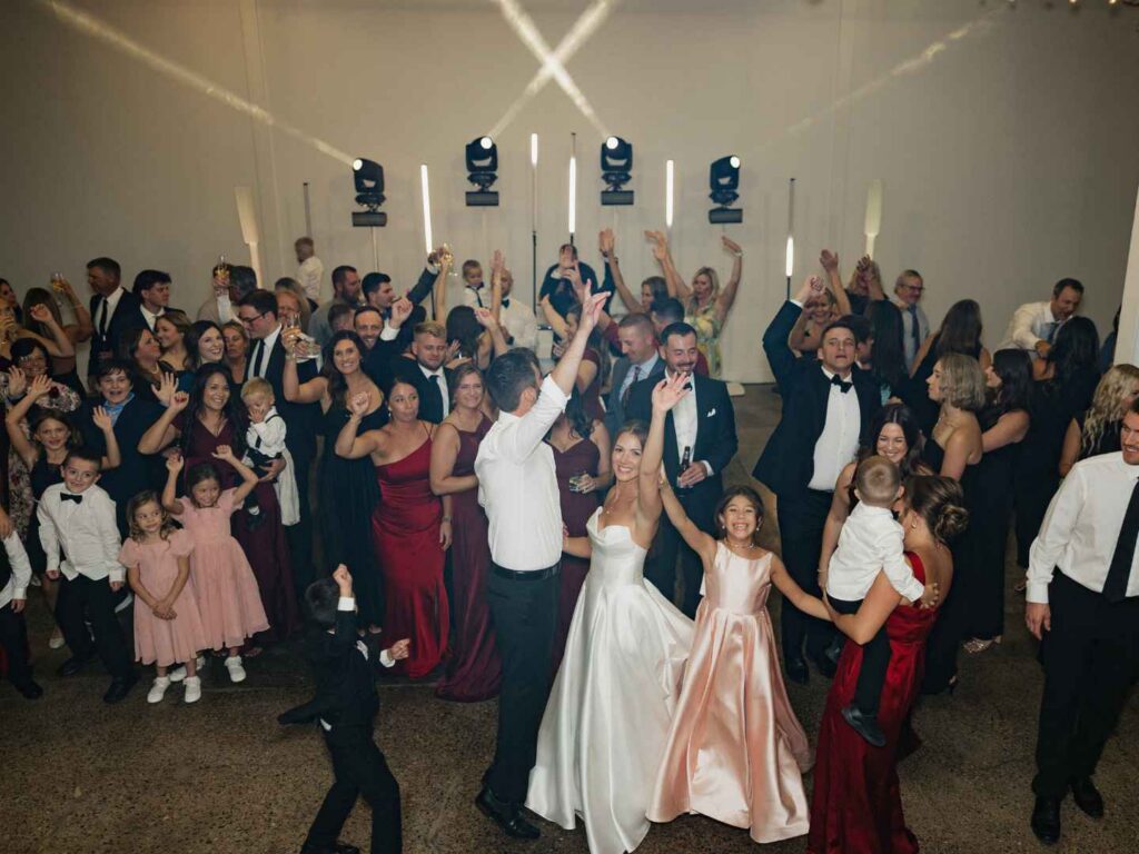 Wedding guests with hands up on a packed dance floor during a nightclub-style Minneapolis wedding