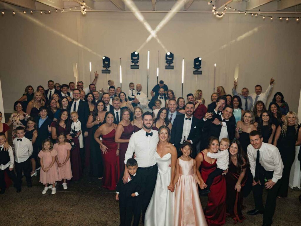 Full wedding group photo of guests posed on the dance floor at The Whim in Minneapolis