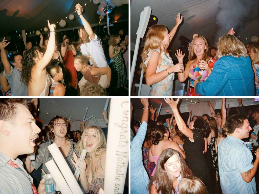 Wedding guests dancing with their hands up under the tent at a lake cottage reception